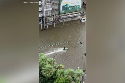 Jet ski rider cruises through flooded streets of Bangkok