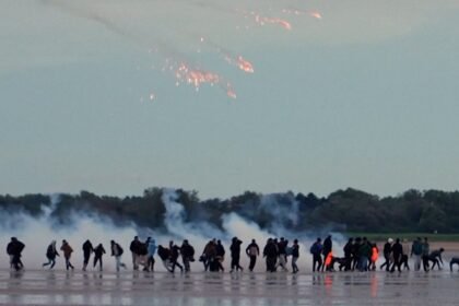 French police fire tear gas at migrants on beach