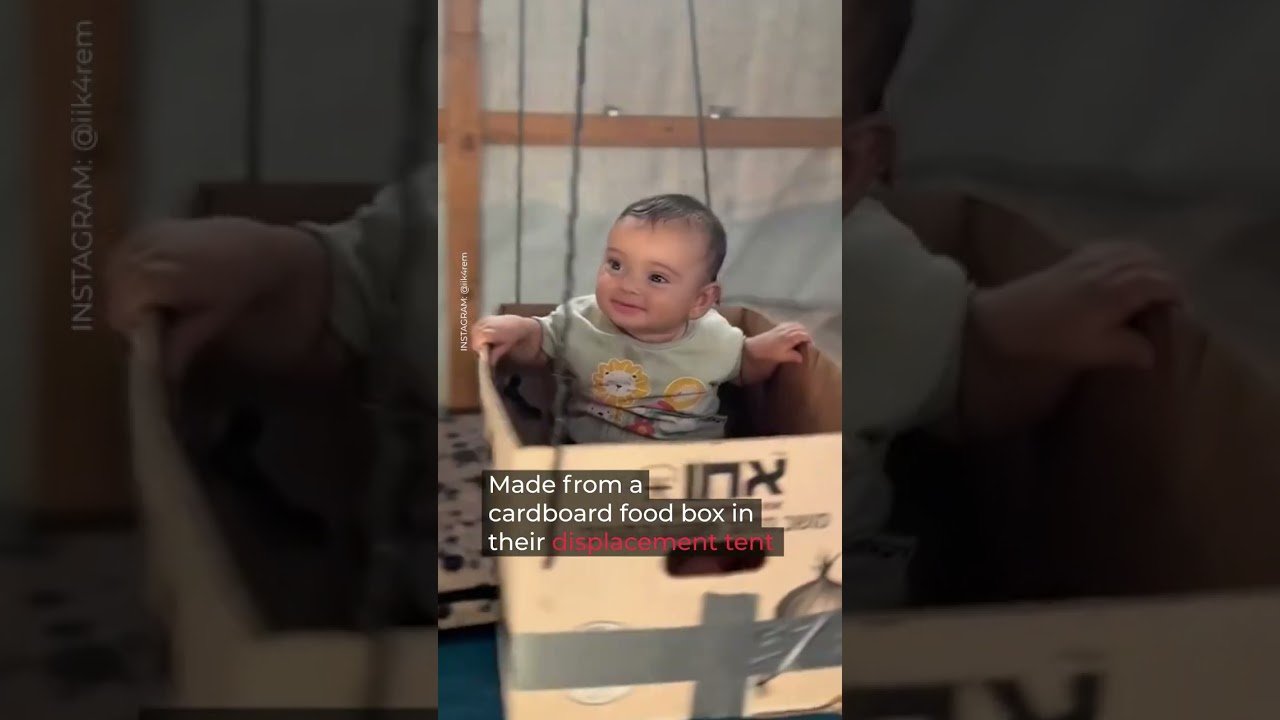 Gaza baby enjoys cardboard swing in displacement tent