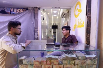 Why has Iraq devalued its currency, and why are some MPs against it?